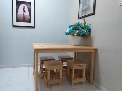 a table and stool with a potted plant on it at AsSalam Homestay in Seri Iskandar