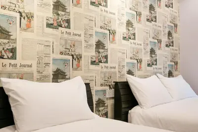 a bedroom with two beds and a wall of newspapers at Canning 33 in Ipoh