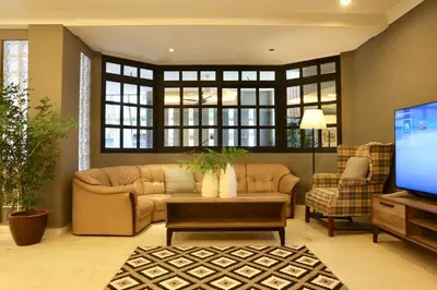 a living room with a couch and a tv at G Beach Front Villa in Batu Ferringhi