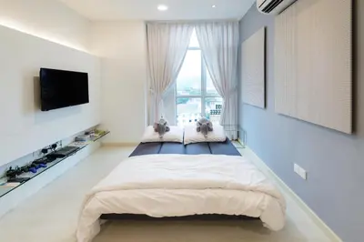 a bedroom with a large bed and a large window at Straits Garden Suites, Georgetown in George Town