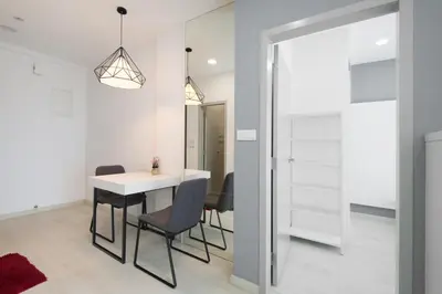 a dining room with a white table and chairs at Straits Garden Suites, Georgetown in George Town