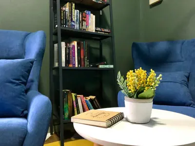 a table with a book and a vase of flowers on it at The Alley's @ Sitiawan, Manjung in Sitiawan