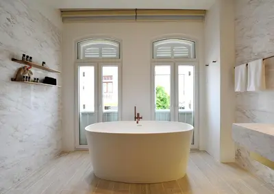 a bath tub in a bathroom with two windows at 88 Armenian in George Town