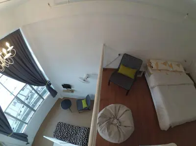 a small bedroom with a bed and a chair at Comfort Zone @ The CEO Loft by Joal in George Town