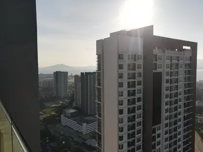 a tall white building with the sun shining on it at Mevin Woodsbury Butterworth Homestay in Butterworth