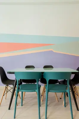 a table and chairs in a room with a wall at ICOLOR HOME & STAY CH1 in Tanah Rata