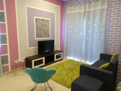 a living room with a couch and a television at ICOLOR HOME & STAY CH1 in Tanah Rata