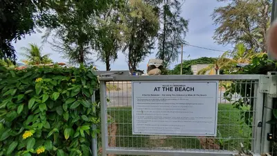 a sign at the beach behind a fence at By The Sea Beach Luxury Resort - Batu Ferringhi in Batu Ferringhi