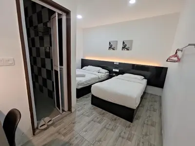 a hotel room with two beds and a mirror at Tambun Warm Hotel in Ipoh
