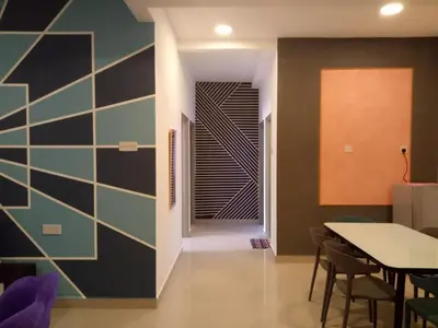 a dining room with a table and a wall at ICOLOR HOME & STAY CH5 in Tanah Rata