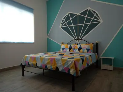 a bedroom with a bed with a colorful comforter at ICOLOR HOME & STAY CH5 in Tanah Rata