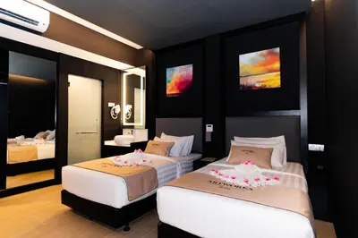 a bedroom with two beds and a mirror at Artworks Hotel Ipoh in Ipoh