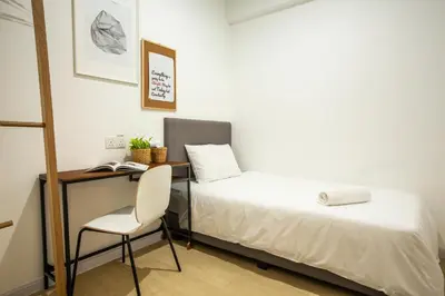 a bedroom with a desk and a bed and a chair at Minima 8 in George Town