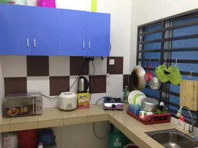 a kitchen counter with a sink and blue cabinets at NUHA HOMESTAY in Seri Iskandar