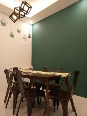 a dining room table with chairs and a green wall at NATURE @ FOREST CAMERON 15 in Tanah Rata