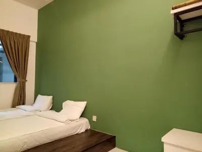 two beds in a room with a green wall at NATURE @ FOREST CAMERON 15 in Tanah Rata