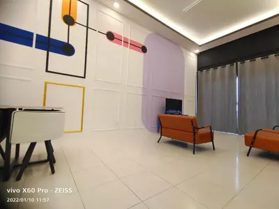 a living room with chairs and paintings on the wall at CLASSIC ENGLISH @ CH in Tanah Rata