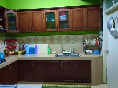 a kitchen with wooden cabinets and a sink at Muslim Dinaim Homestay in Tanjung Malim