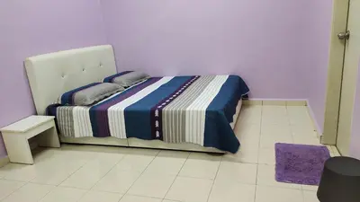 a bedroom with a bed in a purple room at Muslim Dinaim Homestay in Tanjung Malim