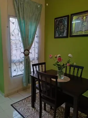 a dining room with a table and chairs and a window at Muslim Dinaim Homestay in Tanjung Malim