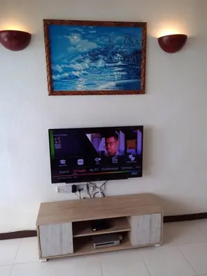 a flat screen tv sitting on a wall at The Barn private home @ Sri Sayang Apartment in Batu Ferringhi