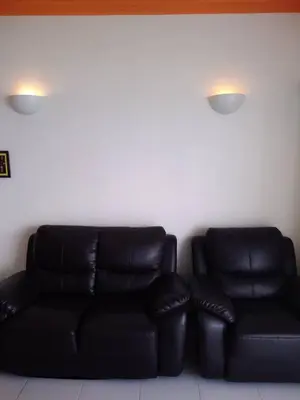 a black leather couch in a room with two lights at The Barn private home @ Sri Sayang Apartment in Batu Ferringhi