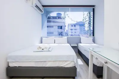 a bedroom with two beds and a window at Nice Inn in George Town