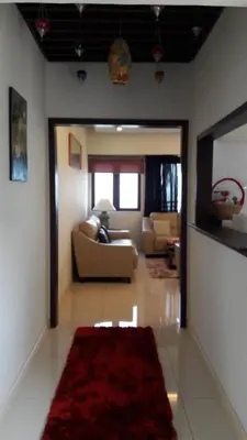 a living room with a couch and a red rug at Susie's VIP Resort Seaview Suite at Sri Sayang in Batu Ferringhi