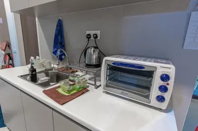 a small kitchen with a microwave and a sink at Cozy Home with Spectacular View in Bayan Lepas