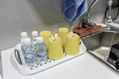 a tray with bottles and cups sitting next to a sink at Cozy Home with Spectacular View in Bayan Lepas