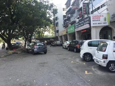 a parking lot with cars parked in front of buildings at Macallum Budget Muslim Homestay in George Town