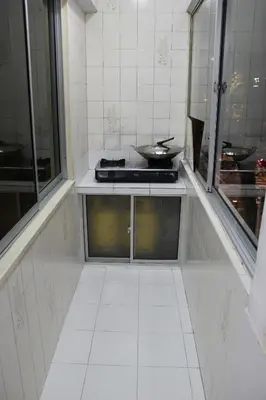 a kitchen with a counter with a stove and mirrors at Macallum Budget Muslim Homestay in George Town