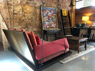 a couch swing hanging from a brick wall at Spices Hotel in George Town
