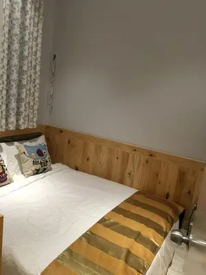 a bed with a wooden headboard in a bedroom at Sekinchan Theme Design Penthouse 16-30Ppax \u4e3b\u9898\u9876\u5c42\u516c\u5bd3\u6c11\u5bbf in Sekincan