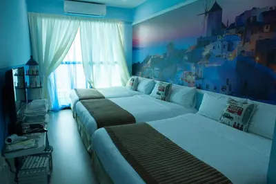 two beds in a hotel room with a painting on the wall at Sekinchan Theme Design Penthouse 16-30Ppax \u4e3b\u9898\u9876\u5c42\u516c\u5bd3\u6c11\u5bbf in Sekincan