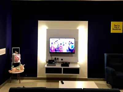 a living room with a tv and a person sitting in a chair at Excellent Location Octagon Studio at Palo 101 Ipoh in Ipoh