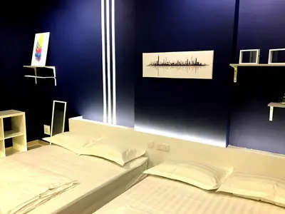 a bedroom with two beds and a blue wall at Excellent Location Octagon Studio at Palo 101 Ipoh in Ipoh