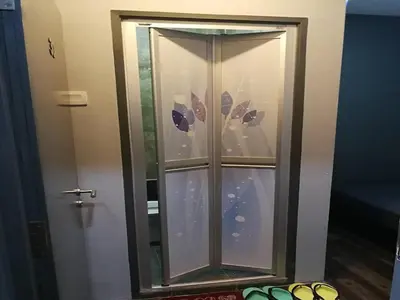 a glass cabinet in a room with a door at Lucky Hotel in Sungai Petani