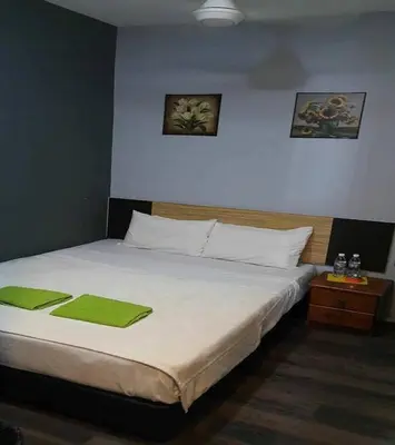 a bedroom with a bed with green towels on it at Lucky Hotel in Sungai Petani