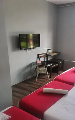 a room with a bed and a table and a tv at Lucky Hotel in Sungai Petani