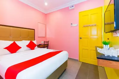 a bedroom with a bed and a yellow door at Hotel O Comfort in Ipoh