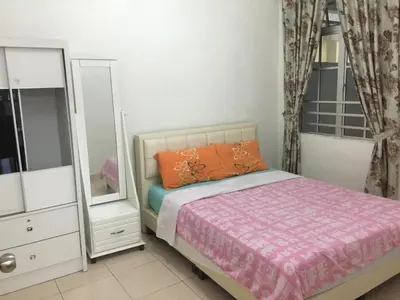 a bedroom with a bed and a dresser and a mirror at Cameron Supersave Apartment @ Crown Imperial Court in Brinchang