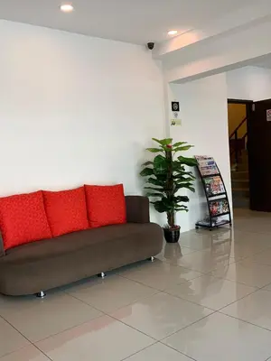 a brown couch with red pillows in a room at Mii Smile Hotel Penang in George Town