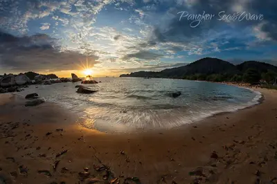 a view of a beach with the sun setting at Sea & Wave #2 Coral Bay Apartment in Pangkor