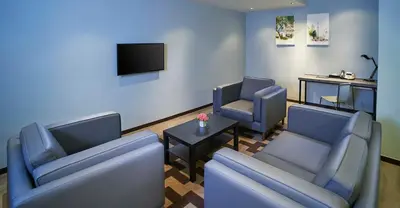 a waiting room with two chairs and a tv at Urban H Hotel in George Town