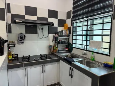 a kitchen with a sink and a stove and a window at Homestay Samsul Sungkai in Sungkai