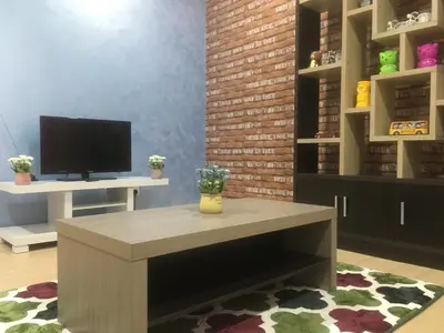 a room with a table and a tv on a shelf at Woodsbury Suites 7722 Butterworth Penang in Butterworth