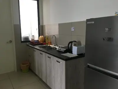 a kitchen with a sink and a refrigerator at Woodsbury Suites 7722 Butterworth Penang in Butterworth