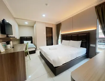 a hotel room with a bed and a television at Hilltop Hotel Tanjung Malim in Tanjung Malim