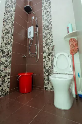 a bathroom with a toilet and a shower and a bucket at GLYSM Tambun Stay 